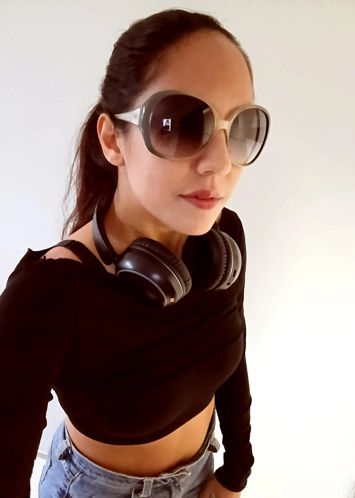 Anastasia wearing sunglasses with headphones around her neck